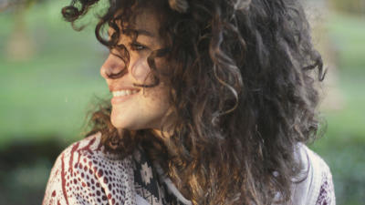 woman with curly hair looking off to the side
